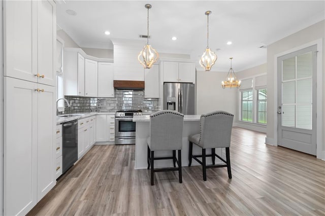 2028 Charles Dr, Chalmette, LA 70043 - kitchen featuring appliances with stainless steel finishes, a chandelier, a center island, a breakfast bar area, and recessed lighting
