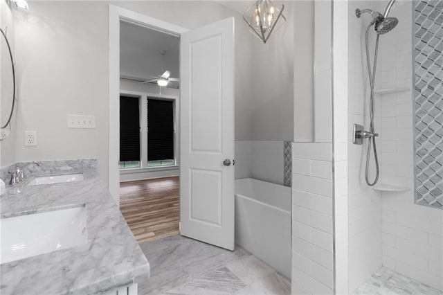 2028 Charles Dr, Chalmette, LA 70043 - bathroom with double vanity, a tile shower, a bathtub, ceiling fan, and a chandelier