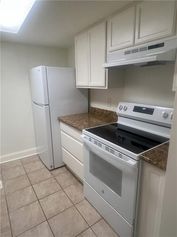 3320 N Arnoult Rd Unit 239, Metairie, LA 70002 - kitchen with white appliances, under cabinet range hood, light tile patterned floors, and white cabinets