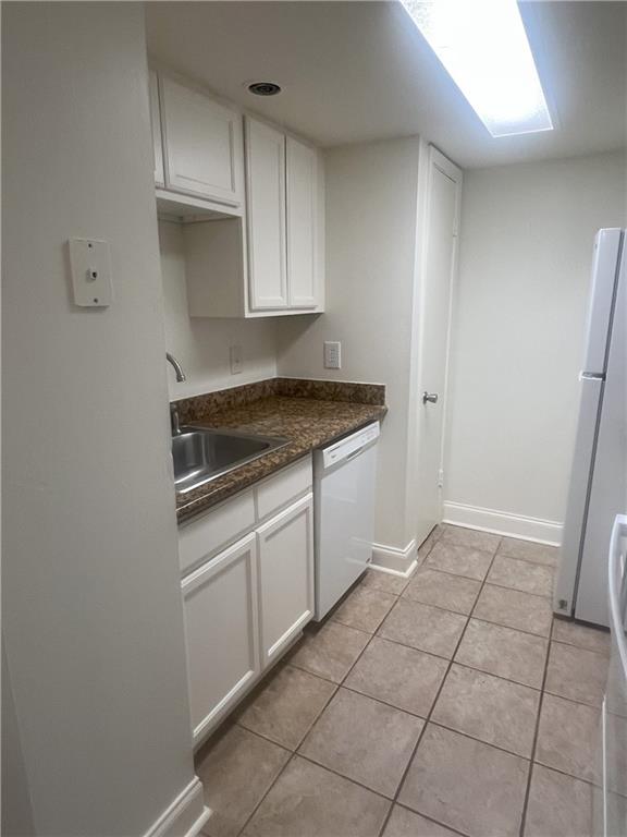 3320 N Arnoult Rd Unit 239, Metairie, LA 70002 - kitchen featuring white appliances, white cabinets, dark countertops, and light tile patterned flooring