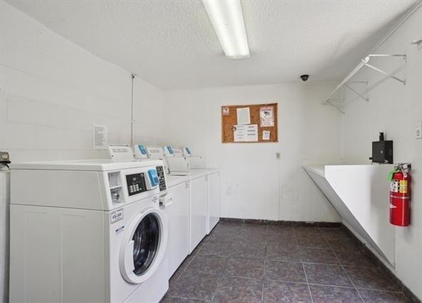 3320 N Arnoult Rd Unit 239, Metairie, LA 70002 - shared laundry room with separate washer and dryer, a textured ceiling, and dark tile patterned floors