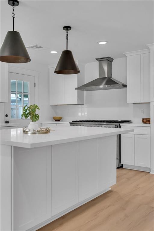 1208 Madison St, Metairie, LA 70001 - kitchen with wall chimney exhaust hood, white cabinets, light countertops, range, and recessed lighting