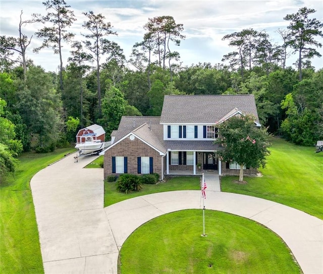 2004 Dierdorff Ct, Slidell, LA 70461 - view of front of house with curved driveway, a front lawn, brick siding, a porch, and a shingled roof