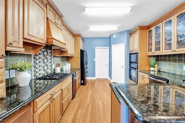 2004 Dierdorff Ct, Slidell, LA 70461 - kitchen with stainless steel appliances, light wood-type flooring, custom range hood, glass insert cabinets, and dark stone countertops