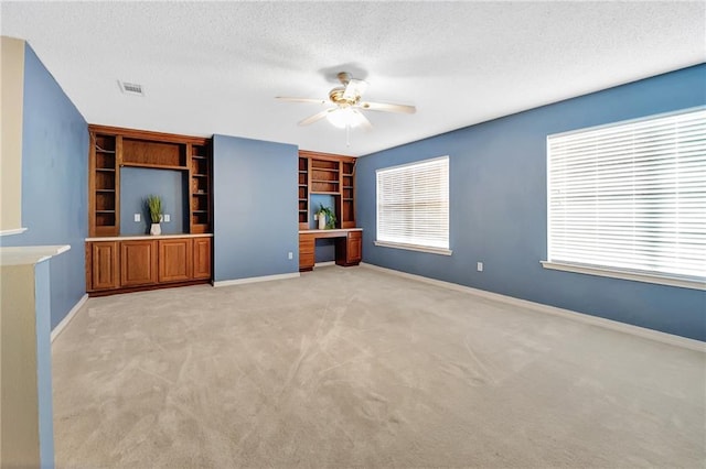 2004 Dierdorff Ct, Slidell, LA 70461 - unfurnished living room with a ceiling fan, a textured ceiling, plenty of natural light, light carpet, and built in features