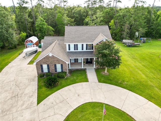 2004 Dierdorff Ct, Slidell, LA 70461 - view of front of home with curved driveway, a front lawn, brick siding, roof with shingles, and a porch