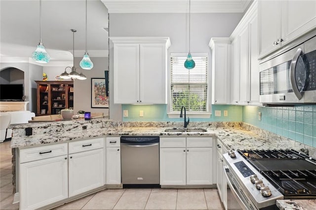 1410 Royal Palm Dr, Slidell, LA 70458 - kitchen with stainless steel appliances, open floor plan, a peninsula, white cabinetry, and ornamental molding