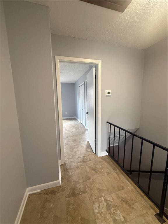 3112 Phoenix St Unit D, Kenner, LA 70065 - hallway with an upstairs landing, a textured ceiling, and stone finish floors