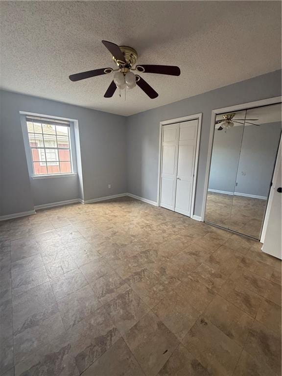 3112 Phoenix St Unit D, Kenner, LA 70065 - unfurnished bedroom featuring multiple closets, a textured ceiling, and a ceiling fan
