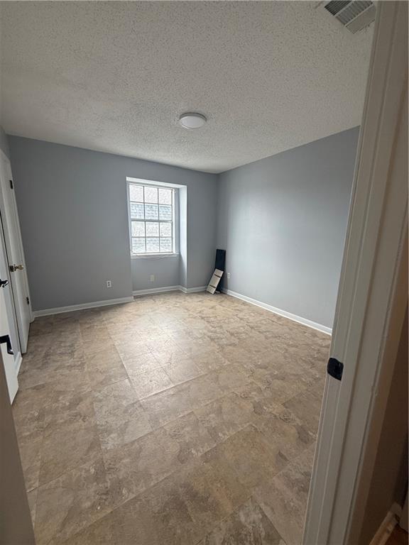 3112 Phoenix St Unit D, Kenner, LA 70065 - unfurnished room with a textured ceiling and baseboards