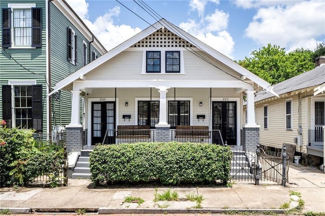 2231 Constance St, New Orleans, LA 70130 - shotgun-style home featuring french doors and a porch