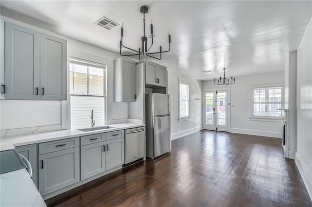 2231 Constance St, New Orleans, LA 70130 - kitchen with a chandelier, appliances with stainless steel finishes, dark wood-style floors, and hanging light fixtures
