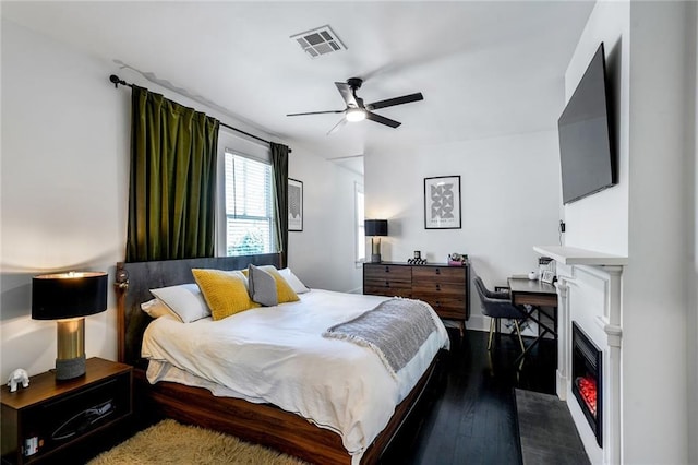2231 Constance St, New Orleans, LA 70130 - bedroom featuring wood-type flooring, a ceiling fan, and a lit fireplace