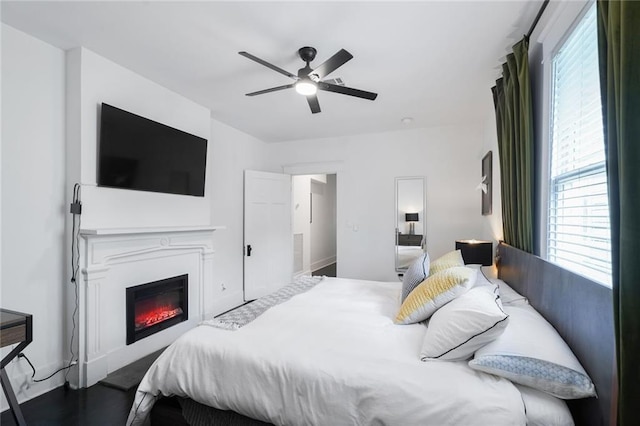 2231 Constance St, New Orleans, LA 70130 - bedroom with a glass covered fireplace, ceiling fan, and wood finished floors