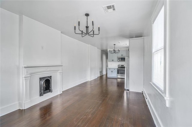 2231 Constance St, New Orleans, LA 70130 - unfurnished living room with a chandelier, dark wood-type flooring, and a fireplace