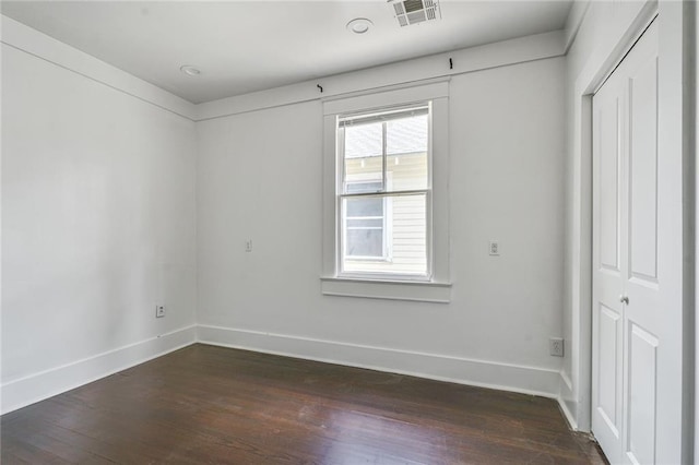 2231 Constance St, New Orleans, LA 70130 - unfurnished bedroom with dark wood-style floors and a closet