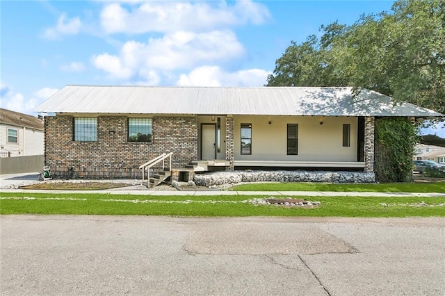6000 Franklin Ave, New Orleans, LA 70122 - view of front facade with brick siding, a metal roof, covered porch, and a front yard