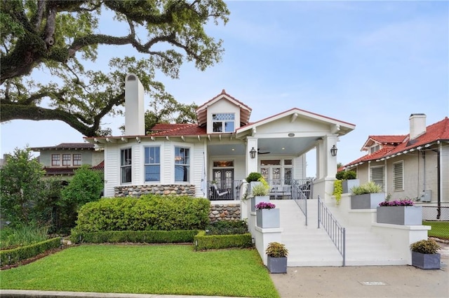 1455 Moss St, New Orleans, LA 70119 - view of front of home with a porch, a front yard, and a chimney