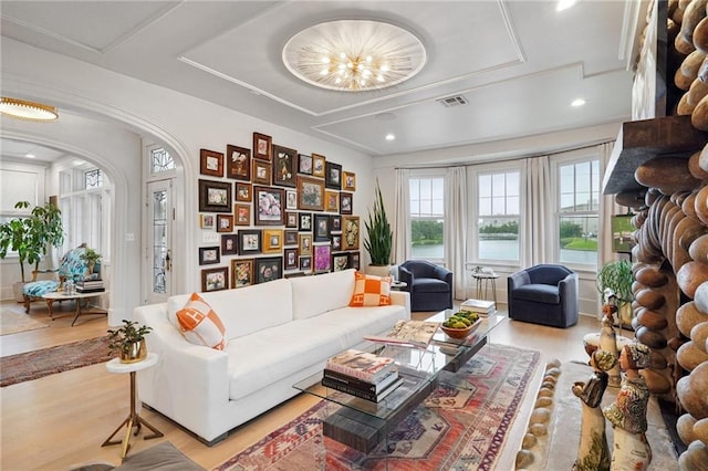 1455 Moss St, New Orleans, LA 70119 - living area featuring light wood finished floors, arched walkways, a tray ceiling, and a water view