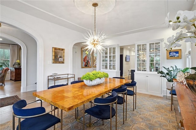 1455 Moss St, New Orleans, LA 70119 - dining room featuring arched walkways, a chandelier, and wood finished floors