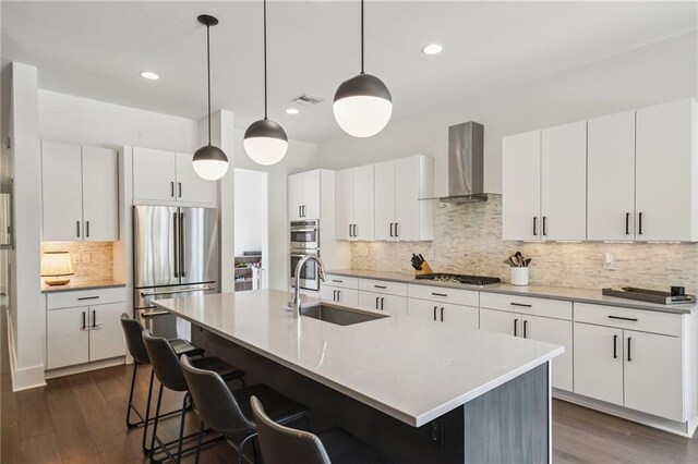 800 Ridgelake Dr, Metairie, LA 70001 - kitchen with wall chimney range hood, stainless steel appliances, backsplash, a kitchen breakfast bar, and dark wood finished floors