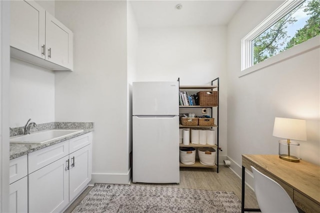 800 Ridgelake Dr, Metairie, LA 70001 - kitchen featuring freestanding refrigerator, light wood-type flooring, white cabinets, and light stone countertops