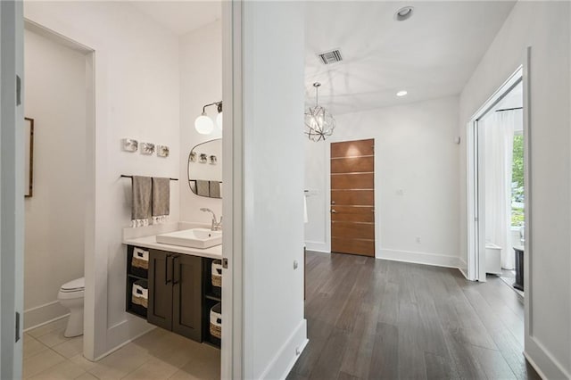 800 Ridgelake Dr, Metairie, LA 70001 - bathroom with vanity, wood finished floors, recessed lighting, and a chandelier