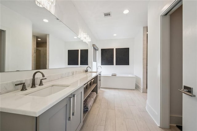 800 Ridgelake Dr, Metairie, LA 70001 - full bath with double vanity, wood finished floors, a tub to relax in, recessed lighting, and a shower with door