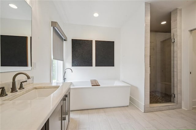 800 Ridgelake Dr, Metairie, LA 70001 - bathroom with a stall shower, vanity, a freestanding tub, wood finished floors, and recessed lighting