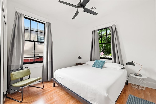 1039-41 Poland Ave, New Orleans, LA 70117 - bedroom with multiple windows, light wood finished floors, and a ceiling fan