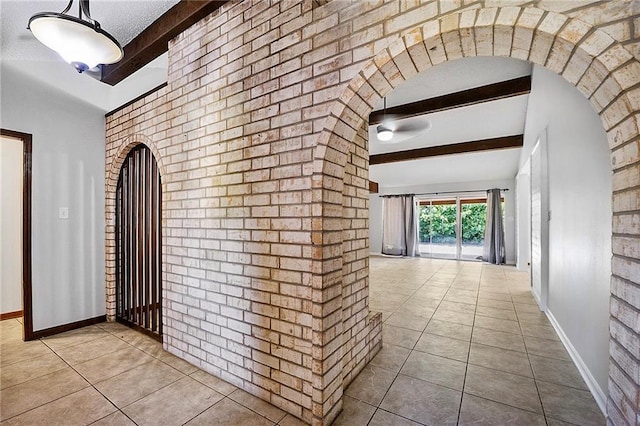 905 Rue Rochelle, Slidell, LA 70458 - hall featuring beam ceiling, tile patterned flooring, arched walkways, and brick wall