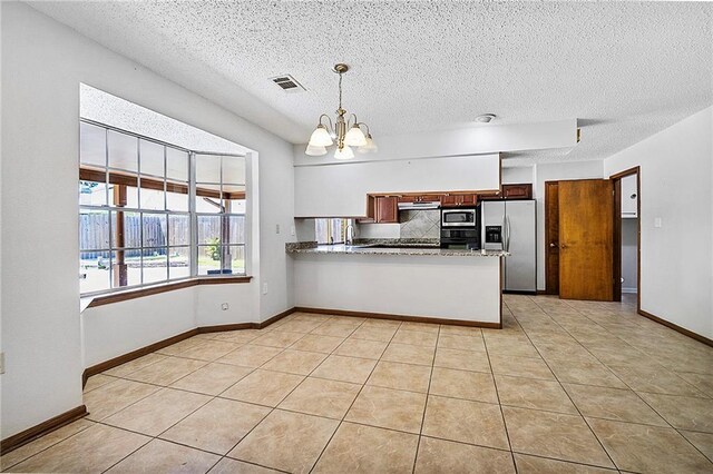 905 Rue Rochelle, Slidell, LA 70458 - kitchen featuring stainless steel appliances, a chandelier, a textured ceiling, a peninsula, and pendant lighting
