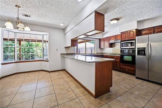 905 Rue Rochelle, Slidell, LA 70458 - kitchen with black appliances, light tile patterned flooring, a peninsula, a textured ceiling, and light stone counters