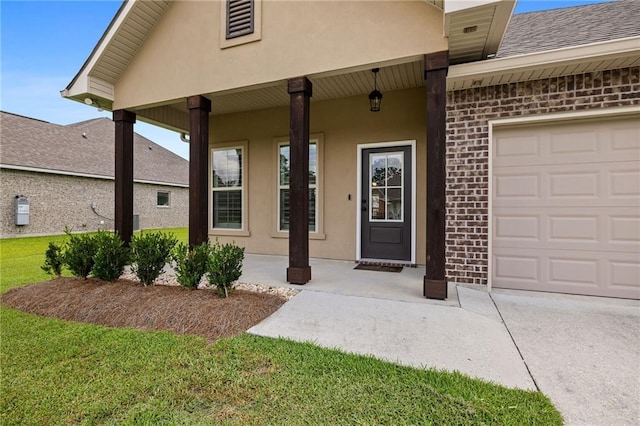 42016 Wood Ave, Ponchatoula, LA 70454 - view of exterior entry featuring brick siding, stucco siding, an attached garage, a shingled roof, and a lawn
