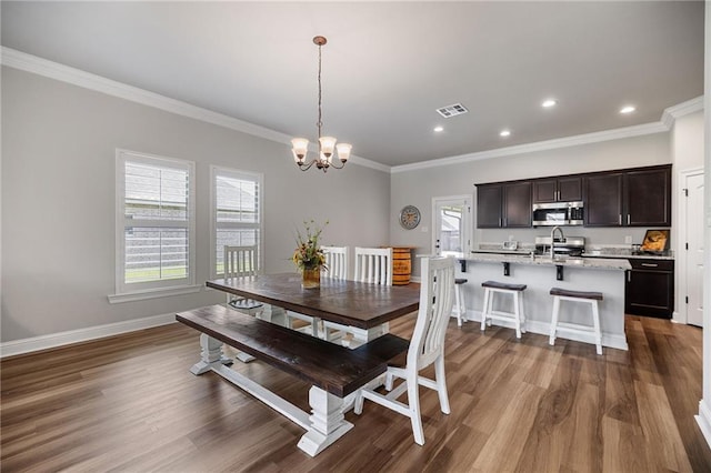 42016 Wood Ave, Ponchatoula, LA 70454 - dining area with ornamental molding, dark wood-style flooring, a chandelier, and recessed lighting