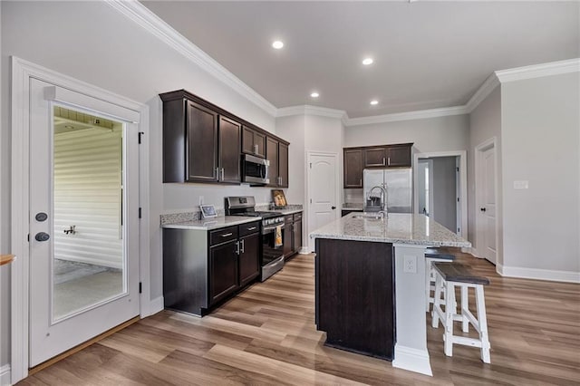 42016 Wood Ave, Ponchatoula, LA 70454 - kitchen with stainless steel appliances, a kitchen breakfast bar, crown molding, light wood-type flooring, and dark brown cabinets