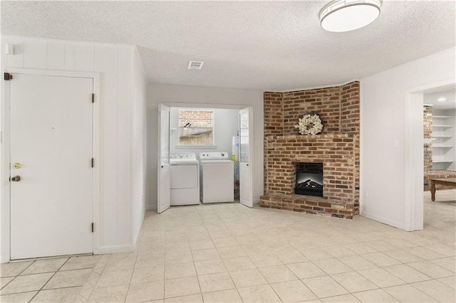 4720 Sheridan Ave, Metairie, LA 70002 - unfurnished living room featuring a textured ceiling, washing machine and dryer, and a brick fireplace