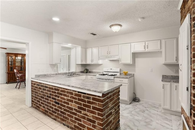 4720 Sheridan Ave, Metairie, LA 70002 - kitchen featuring white gas range, under cabinet range hood, white cabinetry, a peninsula, and a textured ceiling