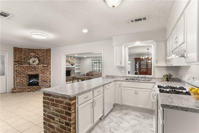 4720 Sheridan Ave, Metairie, LA 70002 - kitchen with white appliances, a fireplace, open floor plan, under cabinet range hood, and white cabinetry