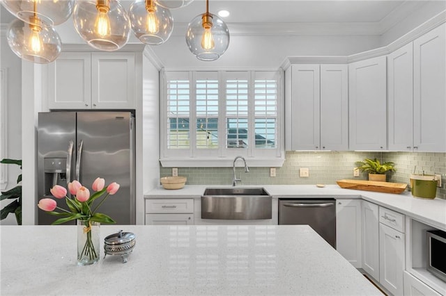 5756 Warrington Dr, New Orleans, LA 70122 - kitchen featuring appliances with stainless steel finishes, ornamental molding, backsplash, white cabinetry, and hanging light fixtures