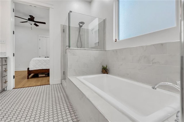 5756 Warrington Dr, New Orleans, LA 70122 - ensuite bathroom featuring a shower stall, a garden tub, vanity, and a ceiling fan