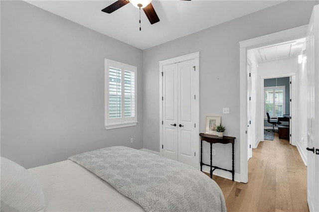 5756 Warrington Dr, New Orleans, LA 70122 - bedroom with attic access, a closet, a desk, light wood-style flooring, and a ceiling fan