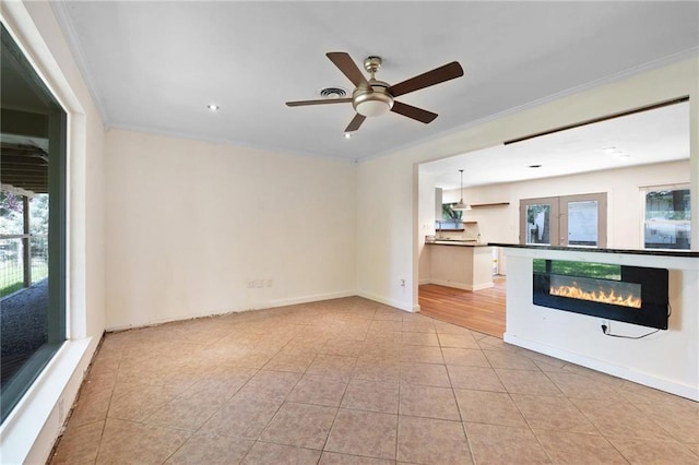 2549 Villere St, Mandeville, LA 70448 - unfurnished living room featuring crown molding, a ceiling fan, light tile patterned floors, and a glass covered fireplace