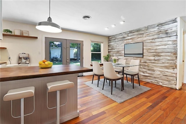 2549 Villere St, Mandeville, LA 70448 - dining area featuring light wood-style floors, an accent wall, and french doors