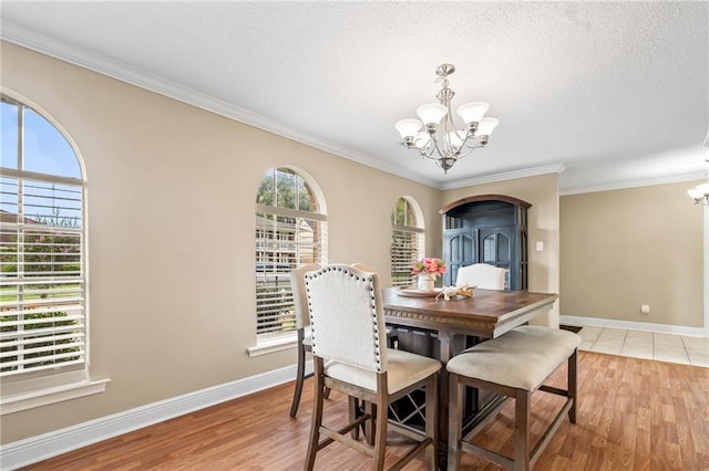3540 Silver Maple Ct, New Orleans, LA 70131 - dining room featuring a chandelier, ornamental molding, light wood-style floors, and a textured ceiling