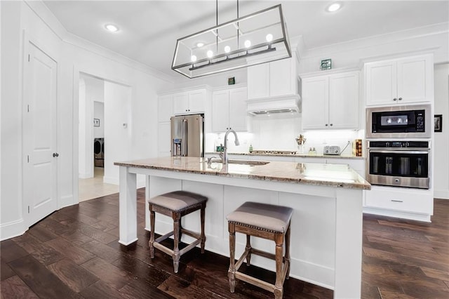 225 Chateau Papillon, Mandeville, LA 70471 - kitchen featuring stainless steel appliances, ornamental molding, a breakfast bar area, a center island with sink, and dark wood-style floors