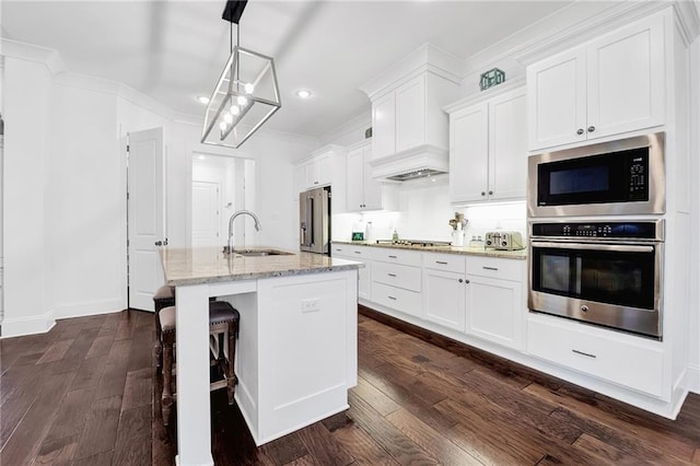 225 Chateau Papillon, Mandeville, LA 70471 - kitchen featuring stainless steel appliances, dark wood-style floors, a kitchen island with sink, white cabinetry, and recessed lighting