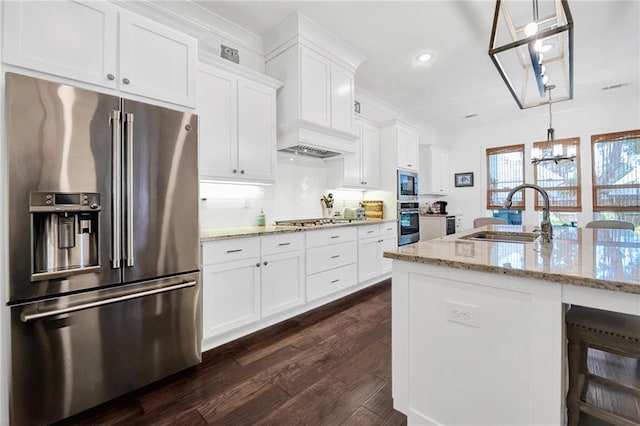 225 Chateau Papillon, Mandeville, LA 70471 - kitchen with stainless steel appliances, a chandelier, white cabinets, dark wood finished floors, and light stone countertops