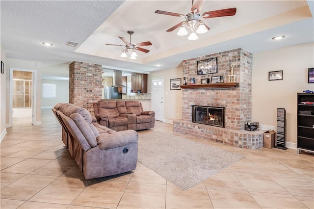 122 Warwick St, La Place, LA 70068 - living room with light tile patterned floors, a ceiling fan, a fireplace, a textured ceiling, and recessed lighting