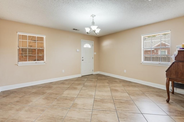 122 Warwick St, La Place, LA 70068 - foyer with a chandelier, a textured ceiling, and light tile patterned floors